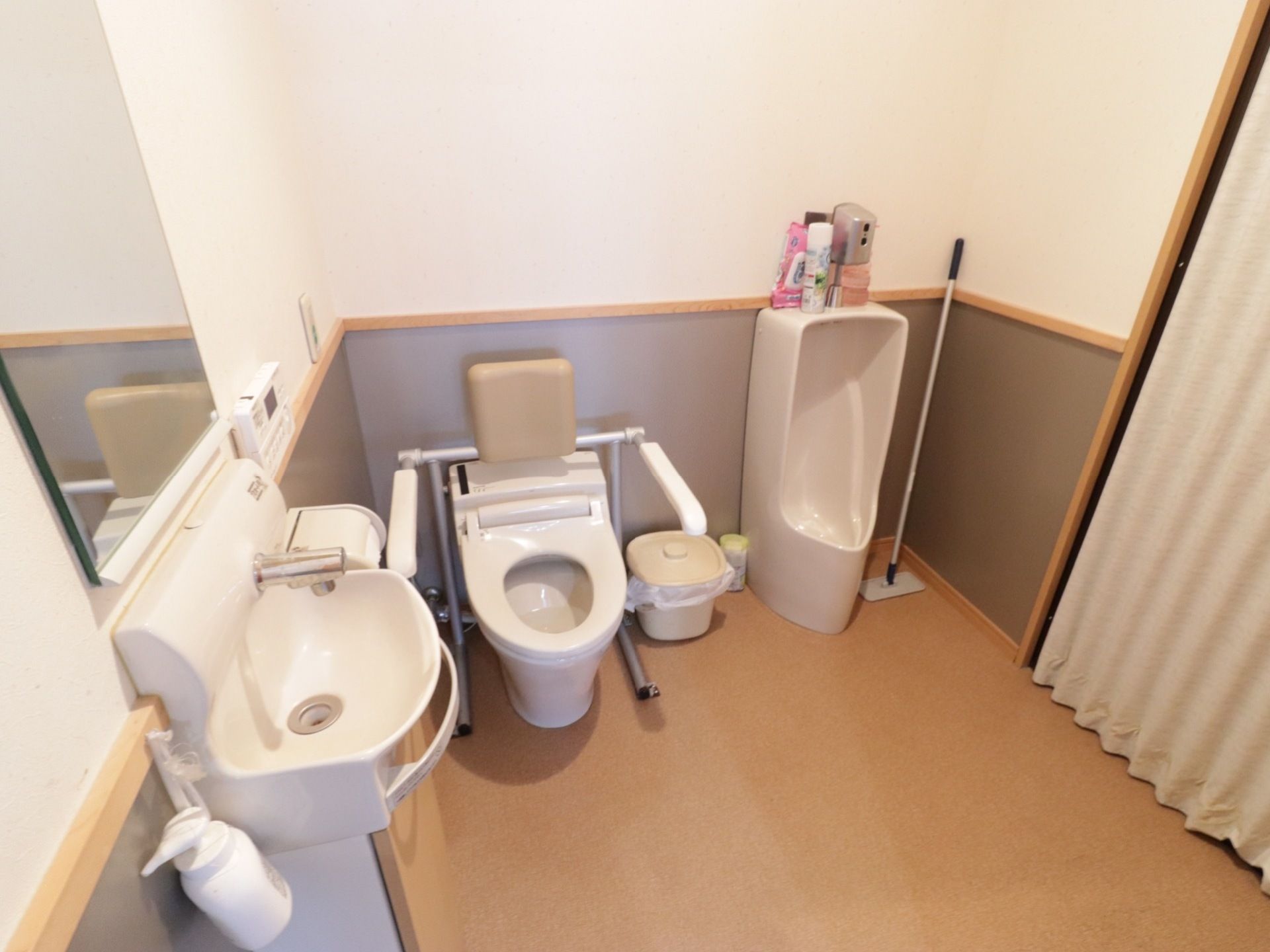 トイレは洋式トイレと別に、男性用便器が用意されている。ごみ箱と掃除用具が置かれ、洗面台にハンドソープが備え付けられている。