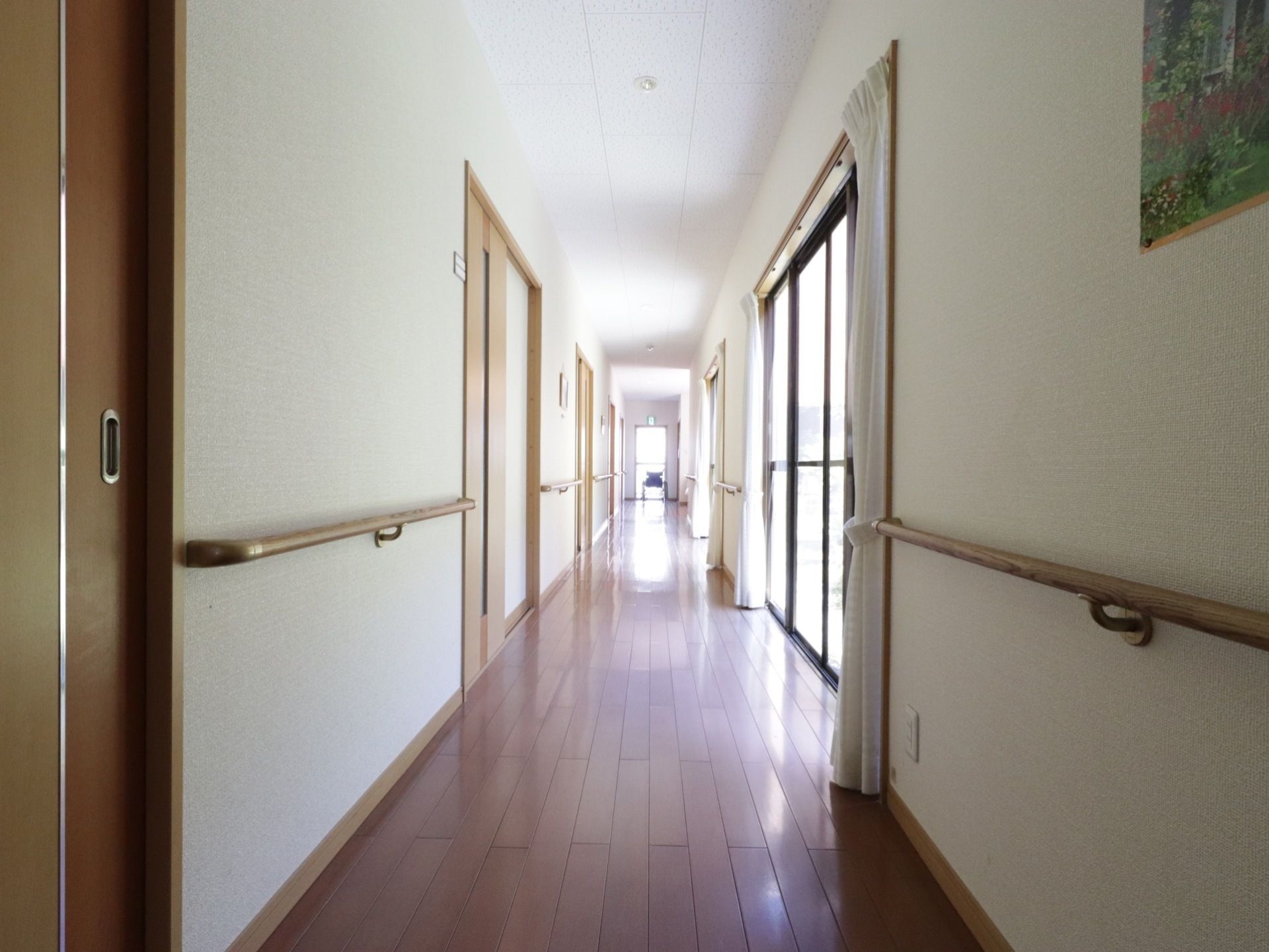 廊下は片側が窓、反対側に居室のドアが並んでいる。壁には手すりが取り付けられている。壁には絵画が飾られている。