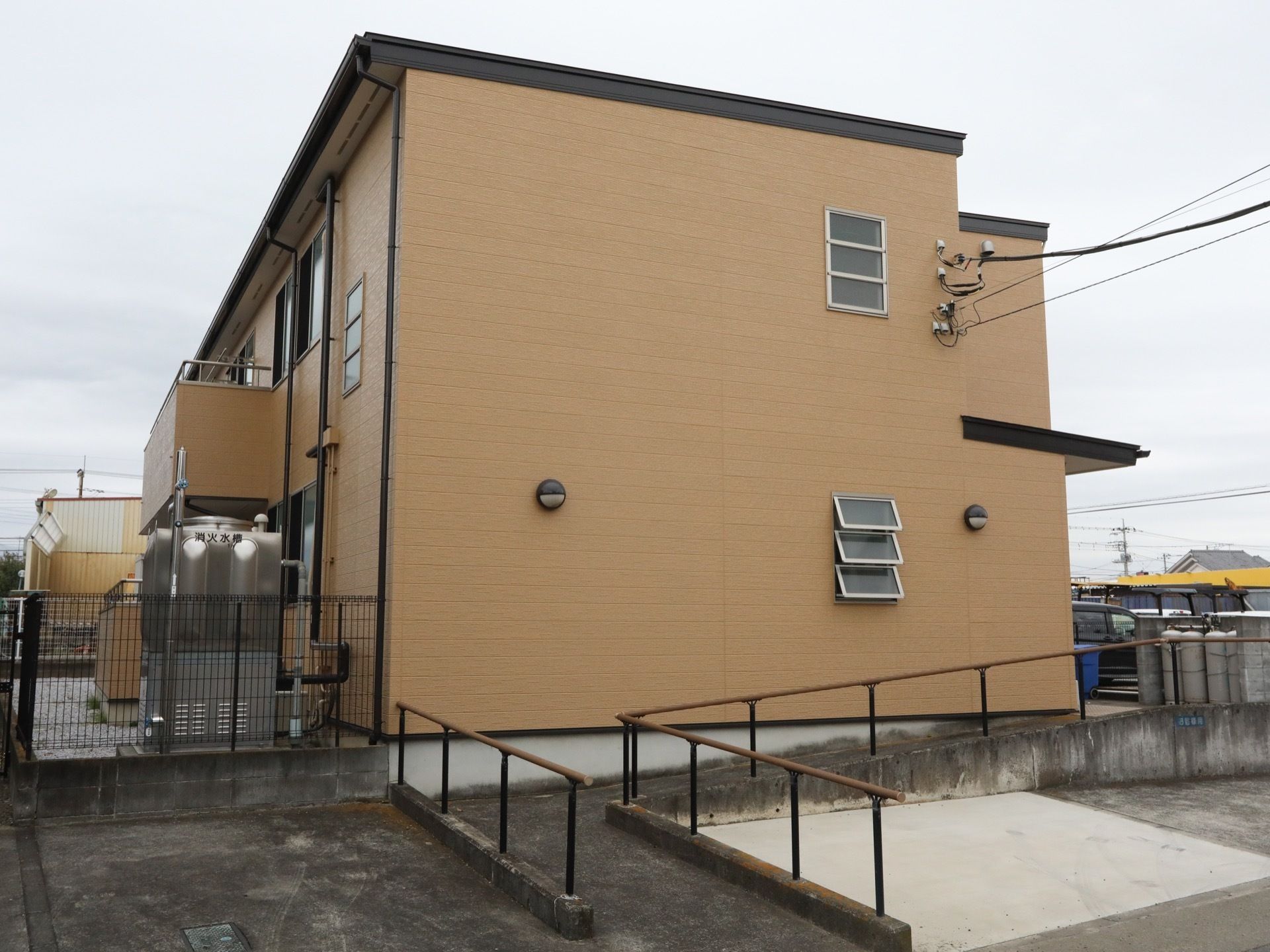 ブラウンを基調とした2階建ての施設。施設の裏に消火水槽が置かれている。また、入口に通じるスロープが設置されている。