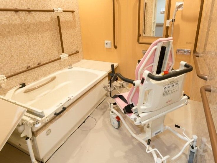 座った姿勢を保てるチェア式の浴槽の様子。壁にはまんべんなく手すりがある様子