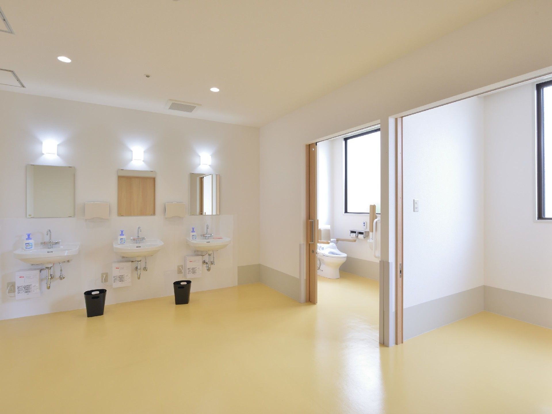 洗面台が並ぶスペースとトイレがある広めの場所。施設内のトイレの様子