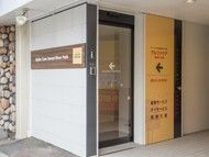 玄関はホテルの王な落ち着いた雰囲気。自動ドアの横には住宅と併設施設の案内がある。