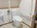 可動式・固定式の手すりがついた介護仕様のトイレの様子