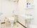 共用設備となっている広いトイレの室内。便器本体には、後付けタイプの手すり兼ひじ掛けが取り付けられている。