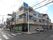 施設は交差点の信号のそばに建っている。施設の建物の１階部分に施設のほか薬局があり、処方箋を扱っている。