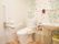 両サイドに手すりが付いたトイレの前方にはバーが付いていて、花柄のクロスが貼られている。