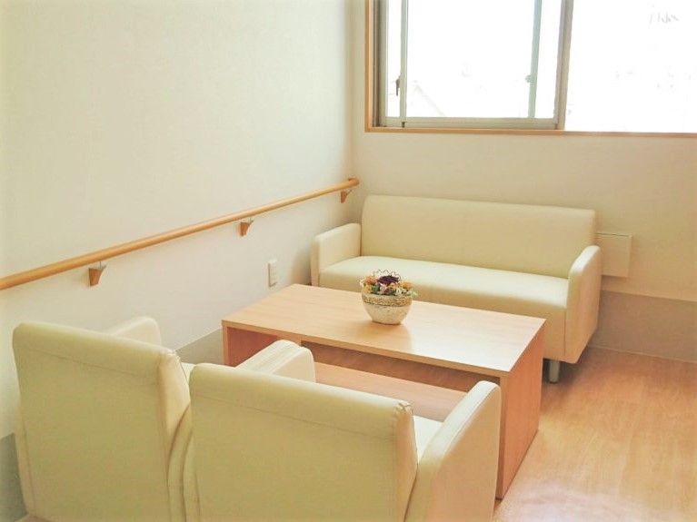 手すりが設置された壁際にはアイボリーのソファの応接セットが置かれている。