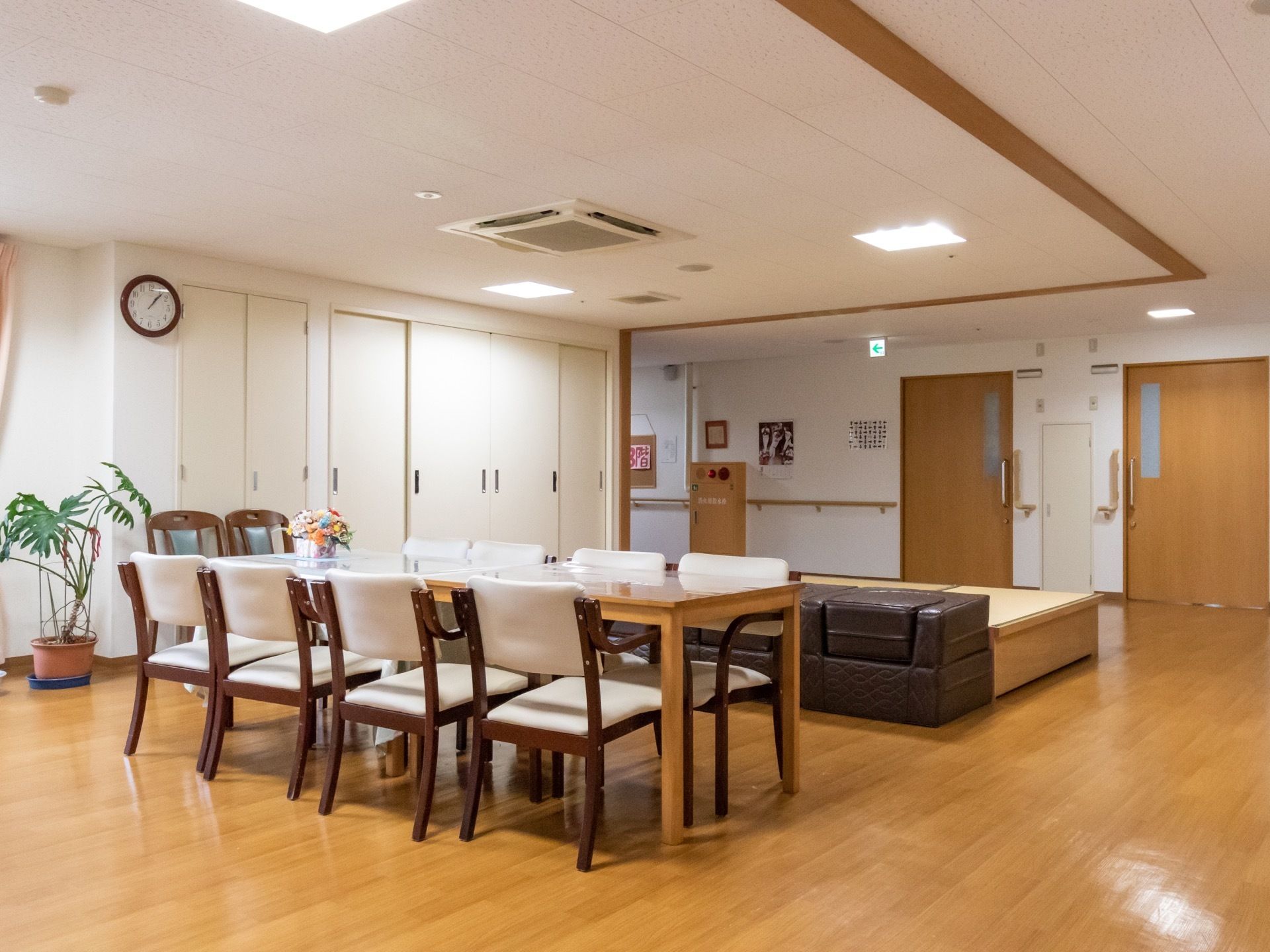 中央におおｋなテーブルがあり、その周りに椅子が置かれている。奥には、居室の入り口扉が並んでいる。扉は引き戸である。
