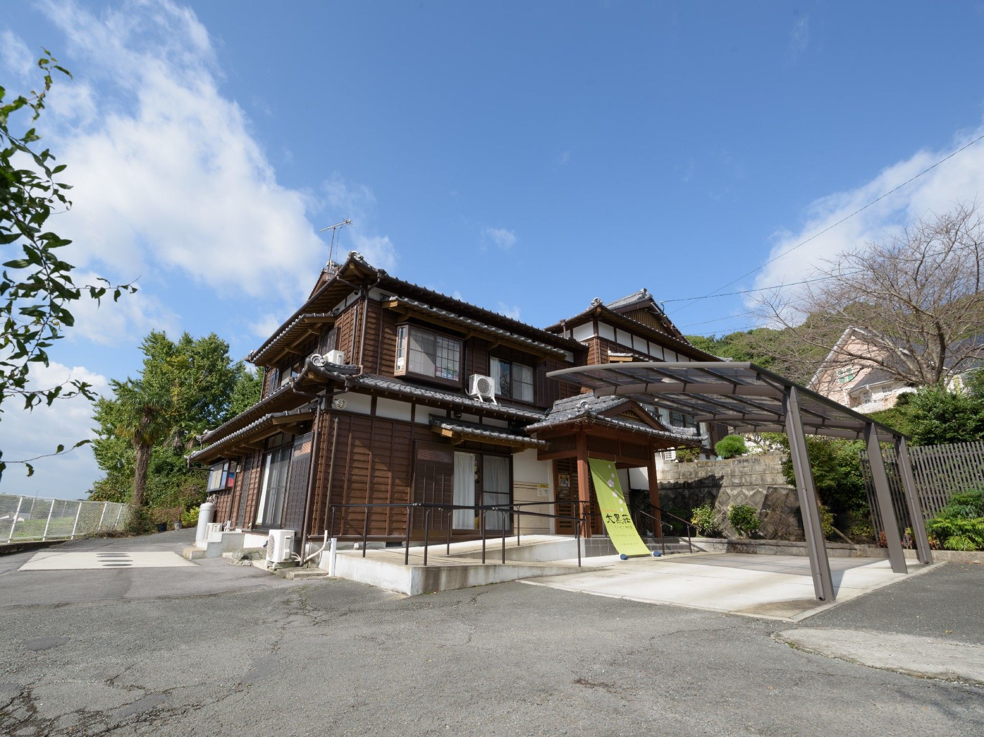 屋外の芝生の上に座って楽しそうに話をしている高齢夫婦と女性の姿