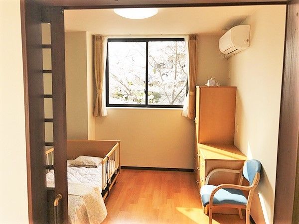 左側にベッド、右側にタンスと椅子、エアコンなどが付いている小さな屋の様子