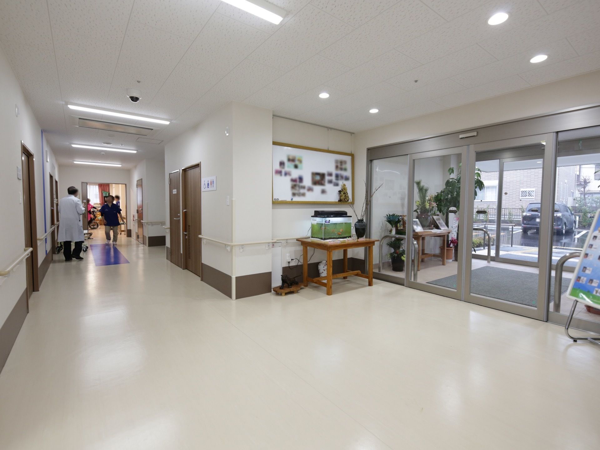 大きなガラス張りの自動ドアの広い玄関がある。ドアは2重扉になっており、足元にはマットが敷かれている。テーブルの上に水槽が置かれている。