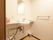 居室内のトイレにある洗面台。壁には鏡とタオルハンガーが付いている。台は広く、物がたくさん置けるようになっている。