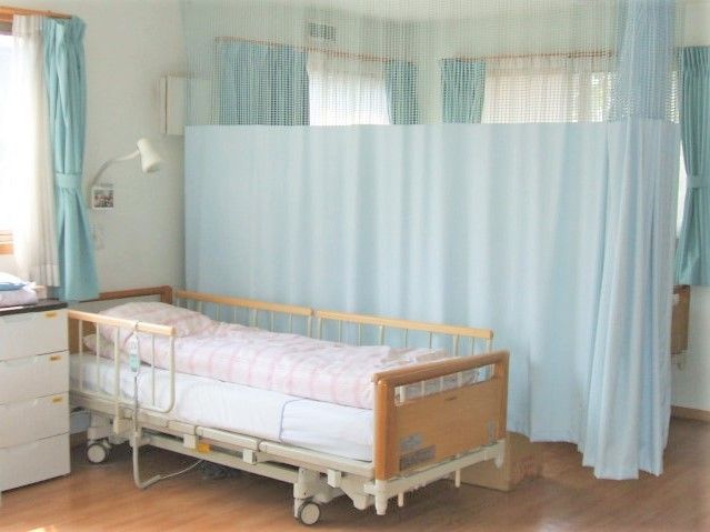 カーテンが引いてある複数人用の部屋。ベッドや調度品が置いてある様子