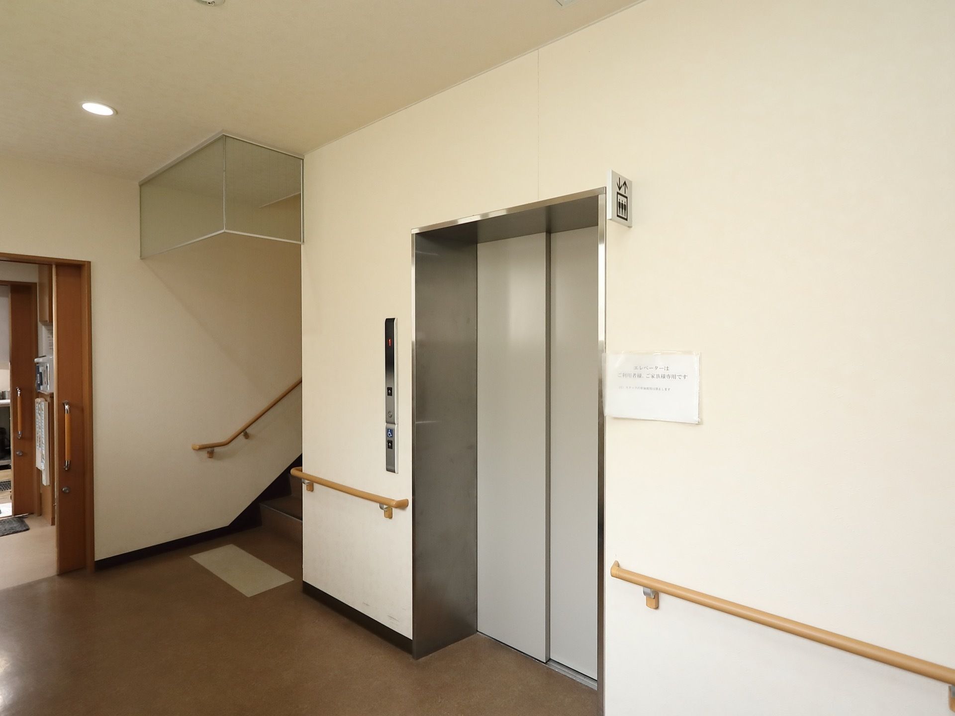 広々としたエレベーターホールである。ドアはグレーで、その両側の壁には手すりを完備している。横側に階段を設けている。