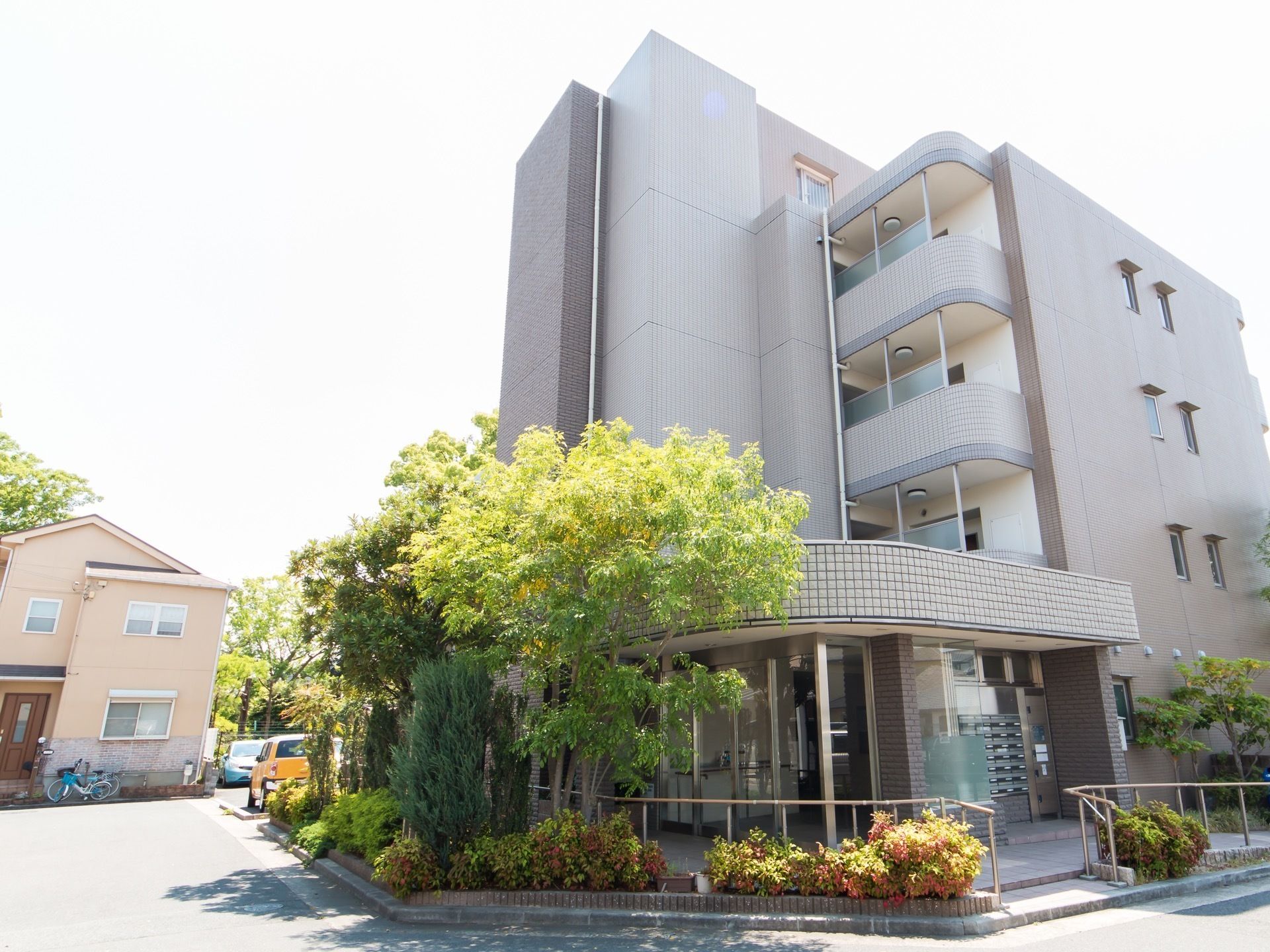 曲がり角から見た施設外観。建物本体は５階建てとなっており、各居室などをつないでいる通路は半屋外式になっている。