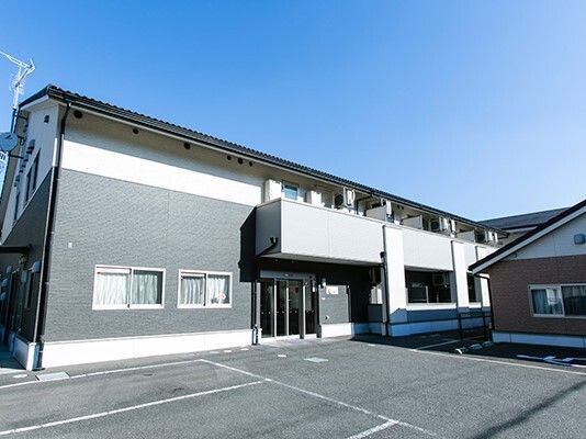 スタッフと高齢者が話している様子。カルテのようなものを書いている場面