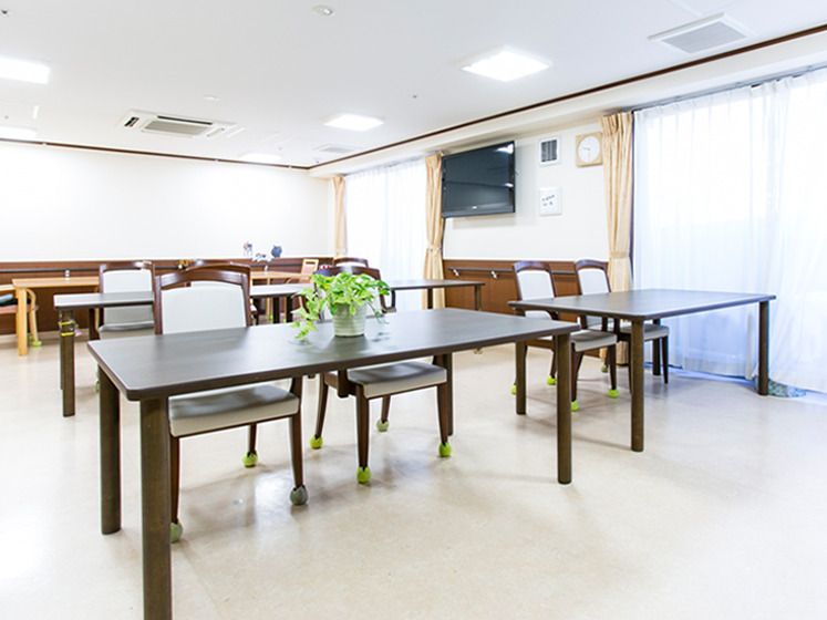 からだを動かしている高齢女性と男性スタッフの様子。施設内で体操しているときの一場面