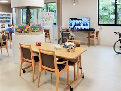 リビングにあるソファやテレビ、テーブル、いすの様子。真ん中にカラフルなおもちゃのようなオブジェがある
