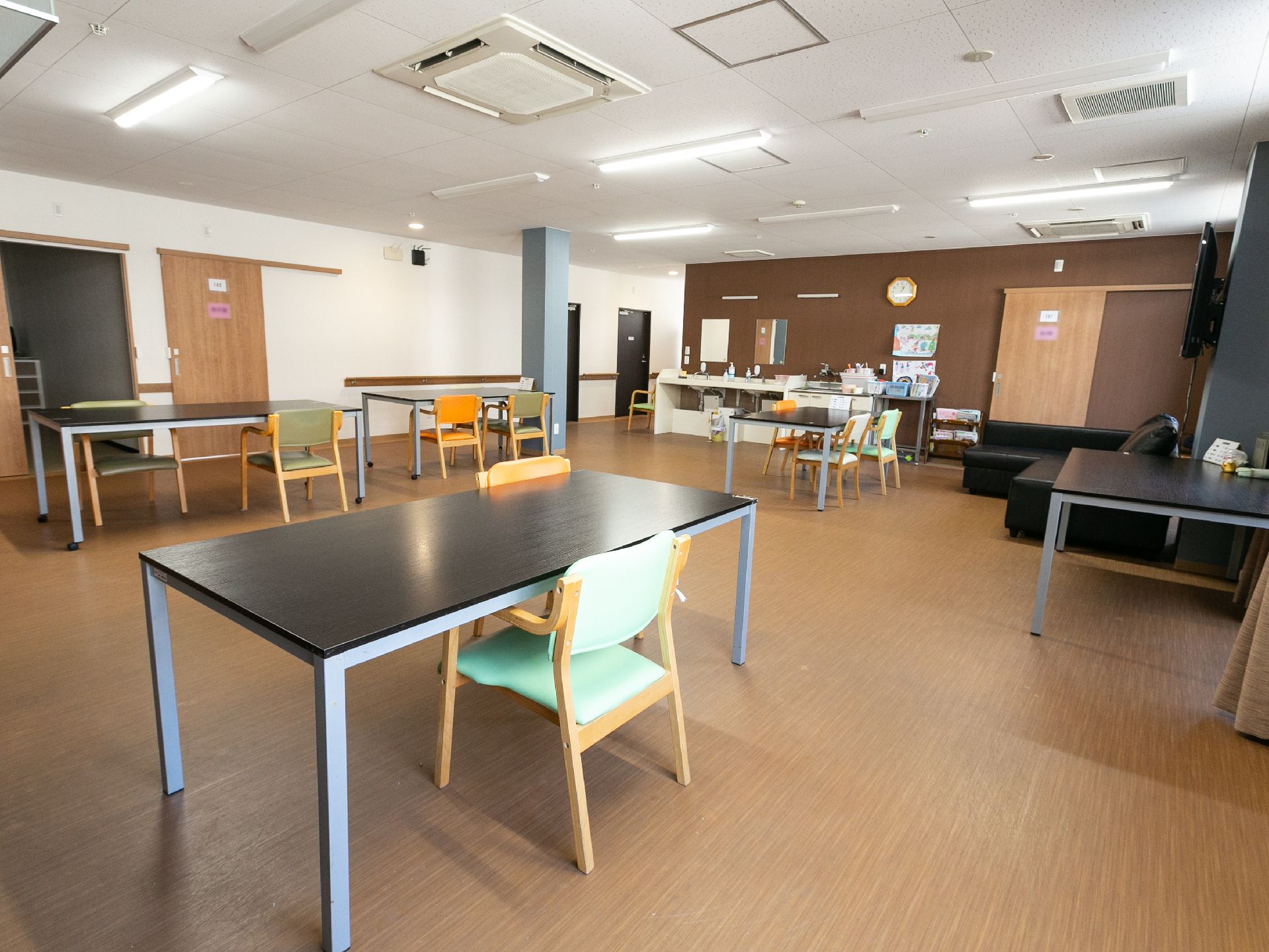 器具を引っ張りリハビリをする高齢女性と理学療法士の男性