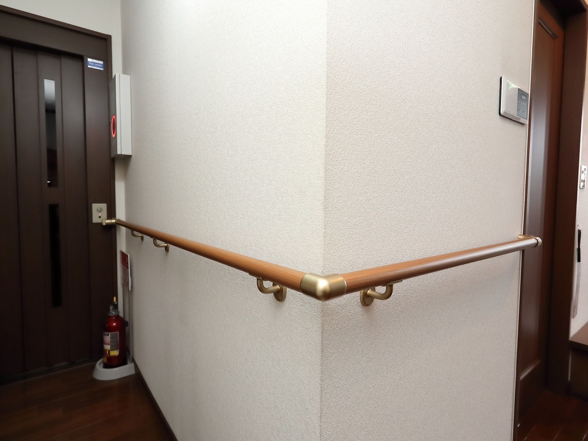 エレベーター乗降口は、上下に２枚のガラス窓がついた扉になっている。乗降口のすぐ横まで手すりが設置されている。