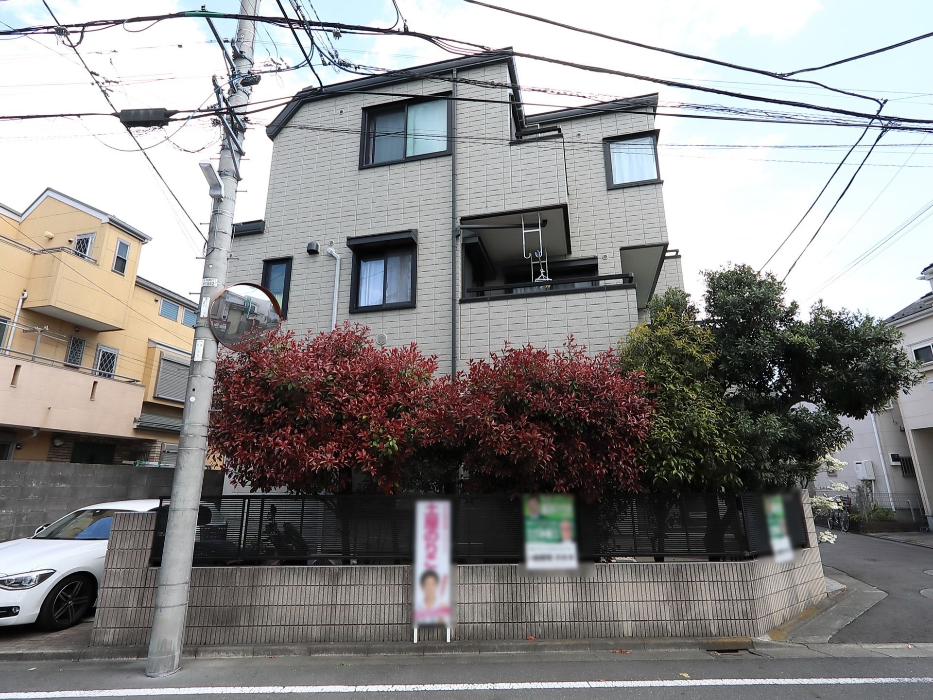 ２面が道路に接している敷地に建つ３階建ての施設である。葉っぱが生い茂っている木々が何本か生えている。