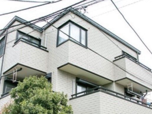 3階建ての一軒家のような外観。洗濯物を干すベランダが見える。