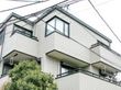 3階建ての一軒家のような外観。洗濯物を干すベランダが見える。