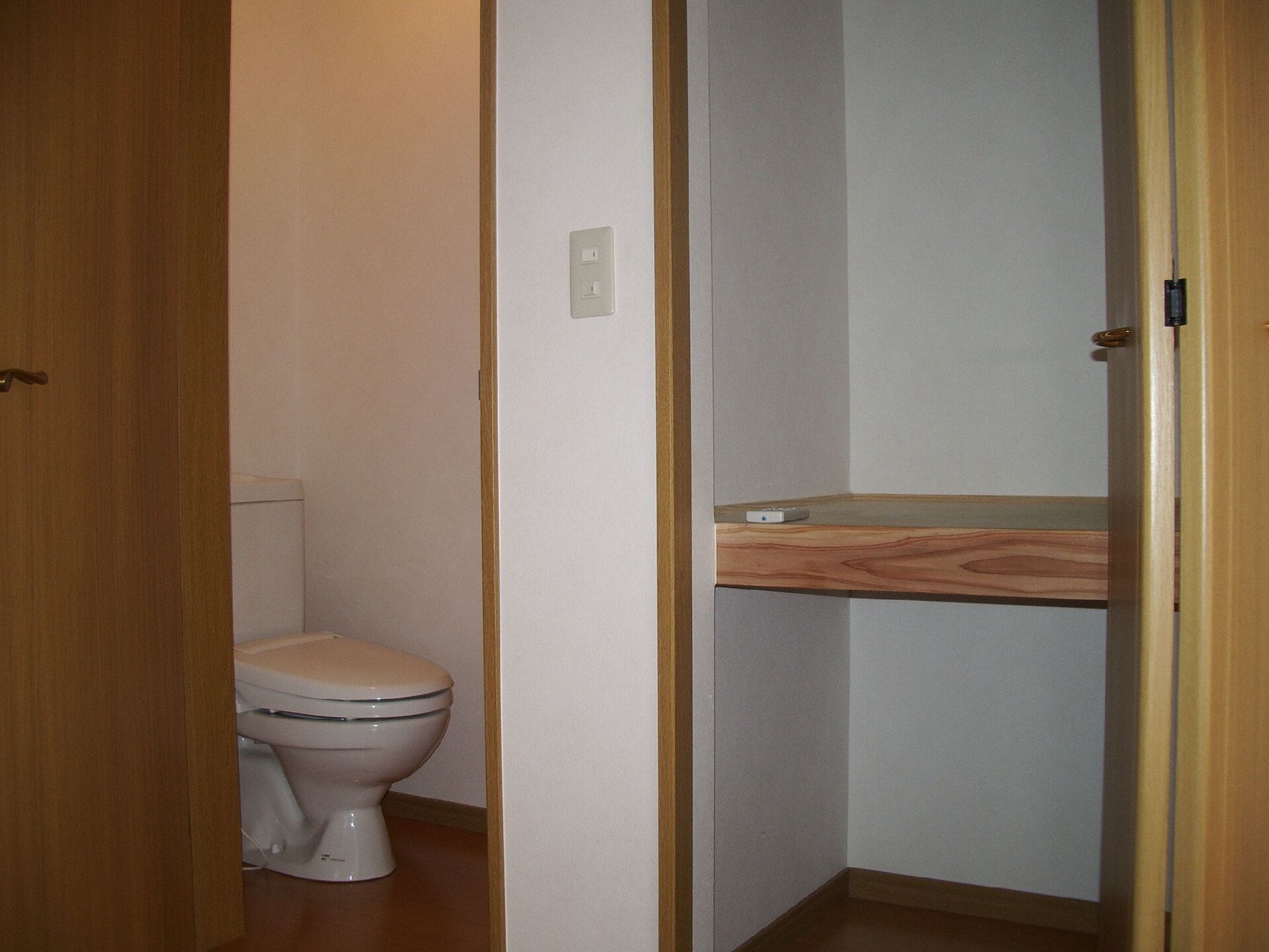 右側には押し入れタイプの収納スペースがあり、左側にはシンプルなトイレが設置されている。