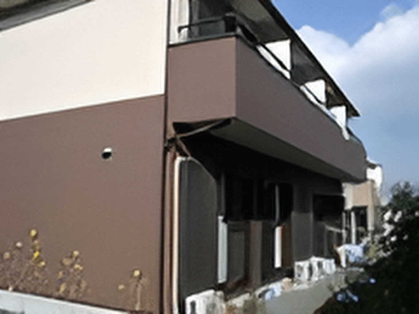 2階建ての建物を側面から見た様子。2階部分にはベランダがあり、各風呂により外壁の色が異なる。