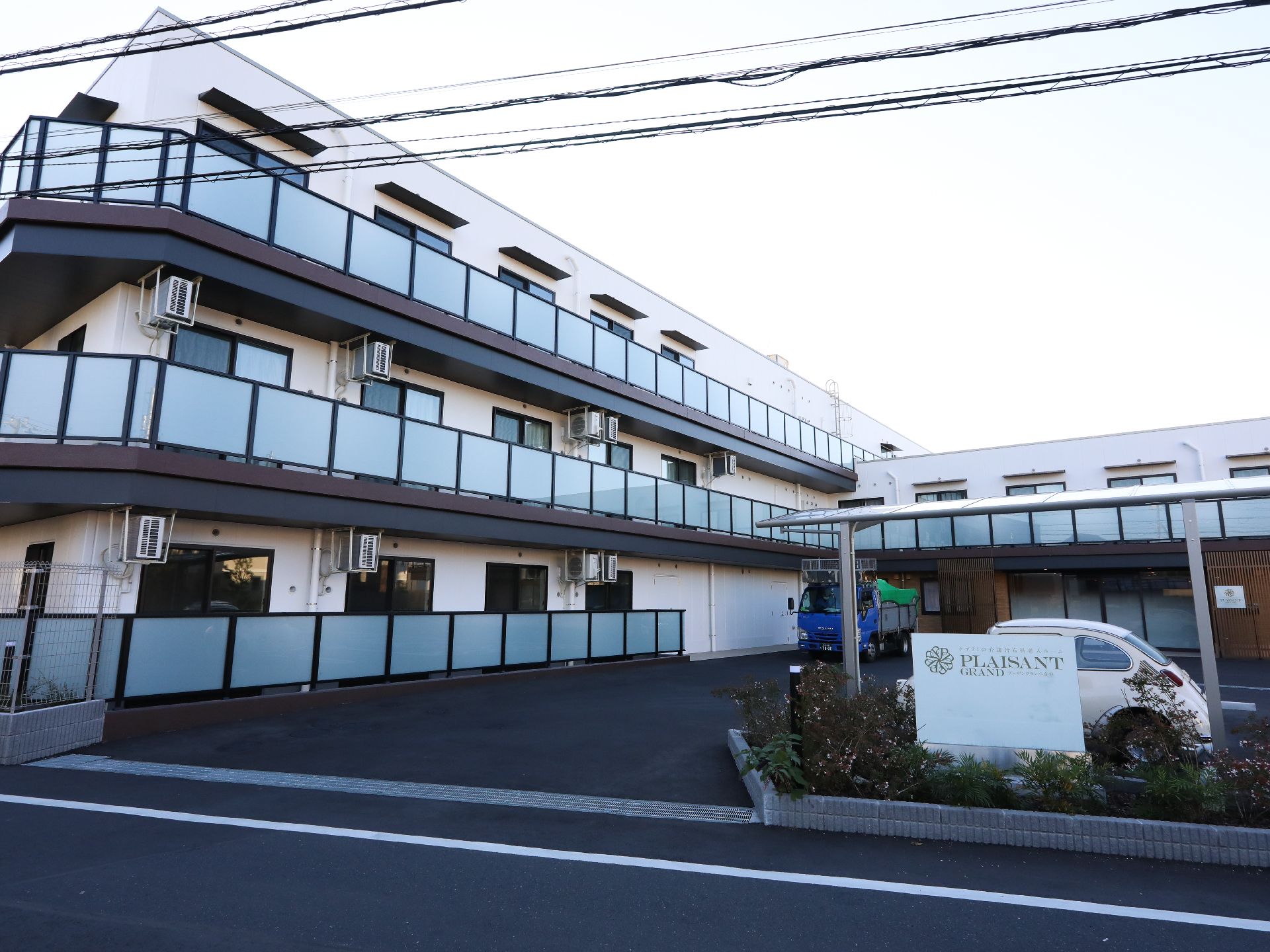 ３階建ての建物は各フロアにベランダがあり、建物の周辺には緑も多くある。