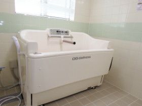 白い機械浴槽が置かれた広い浴室は洗い場がゆったりとしていて、シャワーも設置されている。