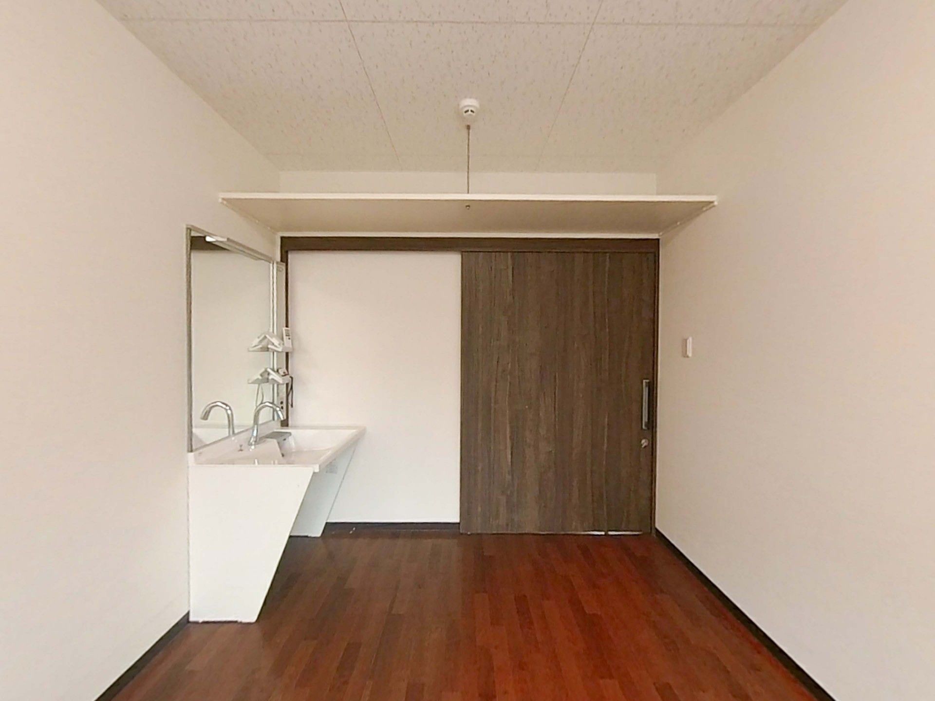 洗面台と木製扉の部屋