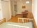 二人用のダイニングテーブルが置かれたフローリングの部屋には介護ベッドやキッチンがある。