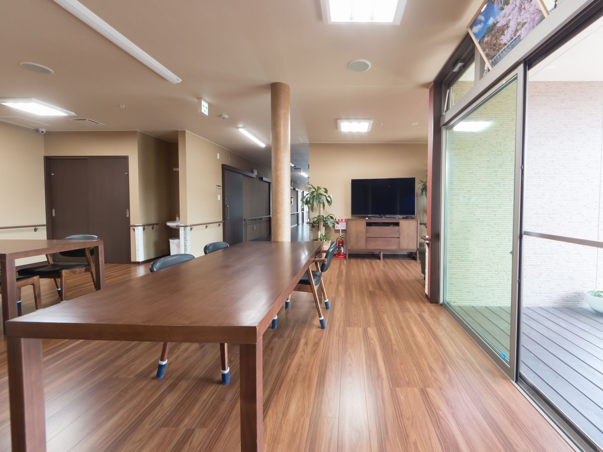 大きな木製のテーブルが置かれている。周りには椅子が数脚あり、それぞれ脚にはカバーが付けられている。