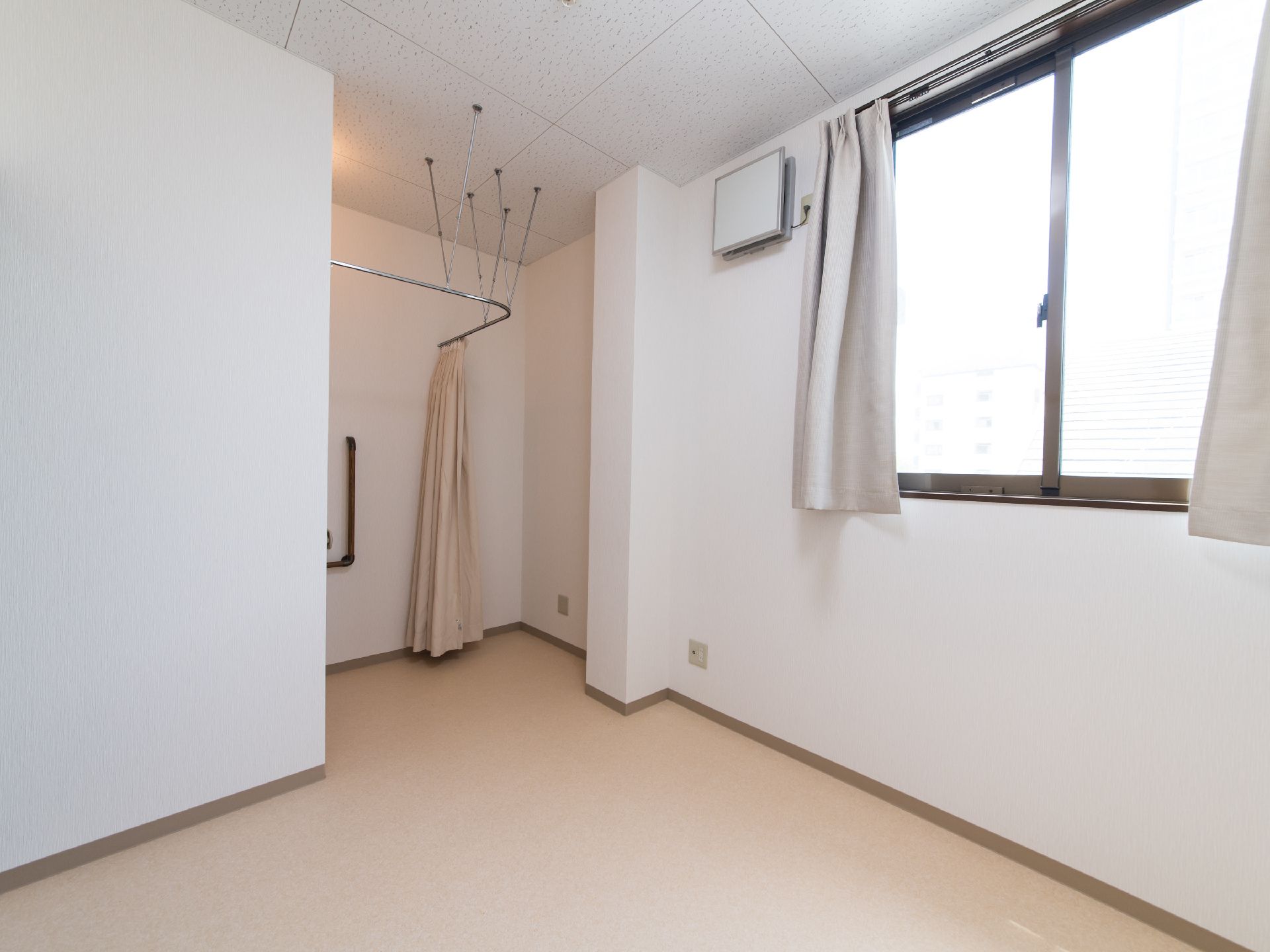 全体的に白で統一された明るい雰囲気の居室。トイレはカーテンタイプになっているので、出入りのストレスがない。