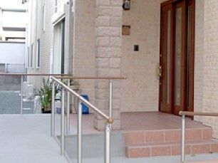 階段やスロープがある施設のエントランス部分。一軒家風の大きめのドア、柱など