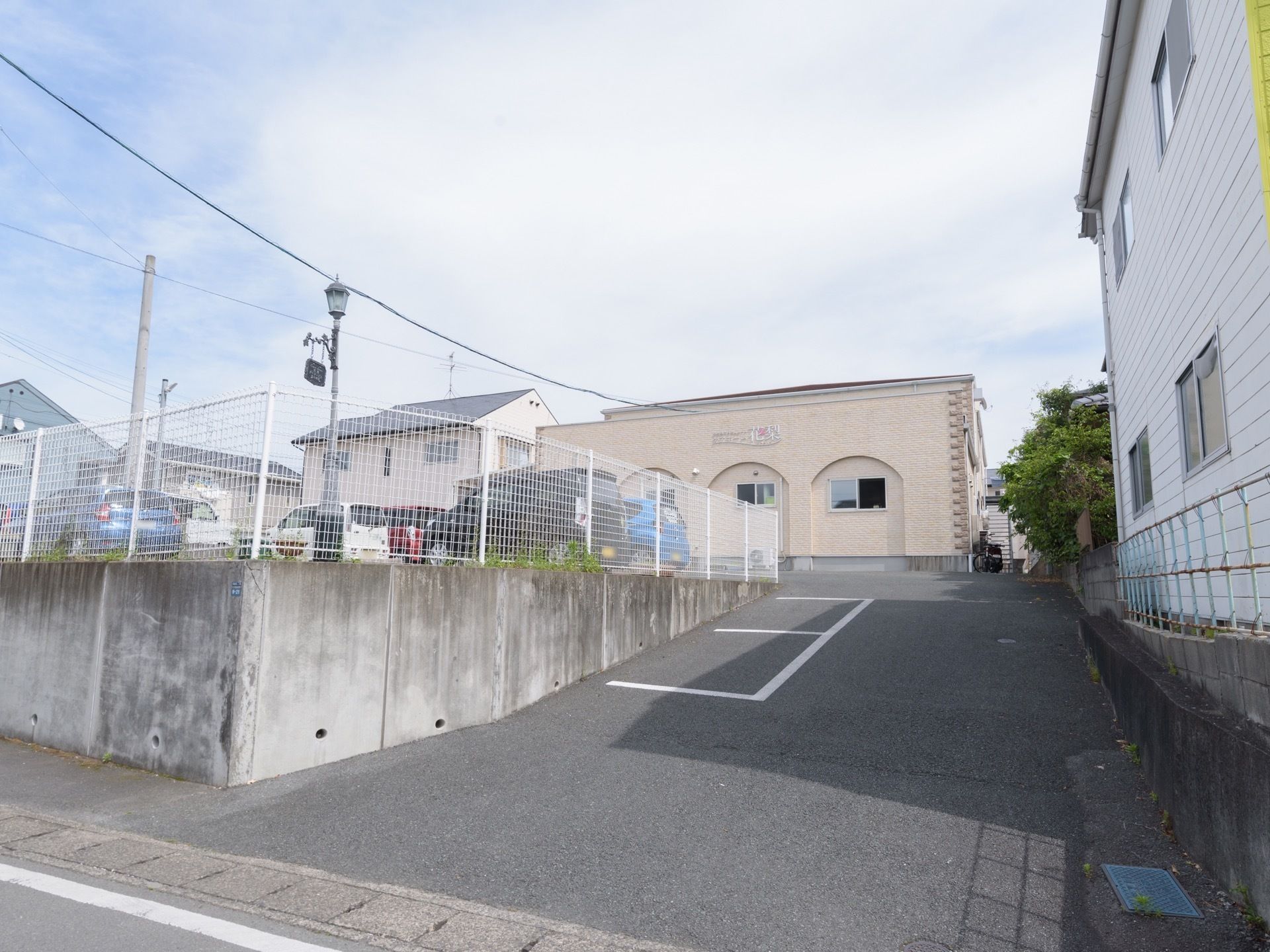 道路面から一段高い敷地に立地している施設である。道路からのスロープに２台分の駐車スペースが表示されている。