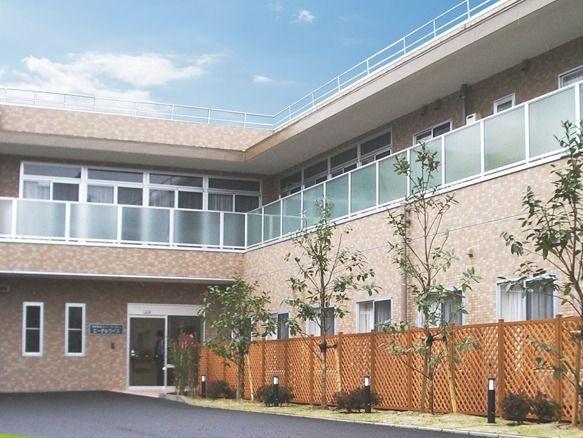 ２階建ての建物はエル字型で、２階にはベランダ、１階には目隠し代わりのラティスが設置されている。
