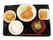 黒いトレーに載った食事。とんかつをメインに白いご飯とみそ汁、フルーツなどが盛りつけられている。