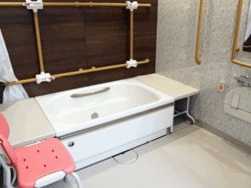 シャワーチェアが設置された浴室には手すりやベンチといった設備がある。