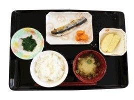 焼き魚をメインとした和風の食事例。フルーツも添えられ、きれいにトレーに盛られている。