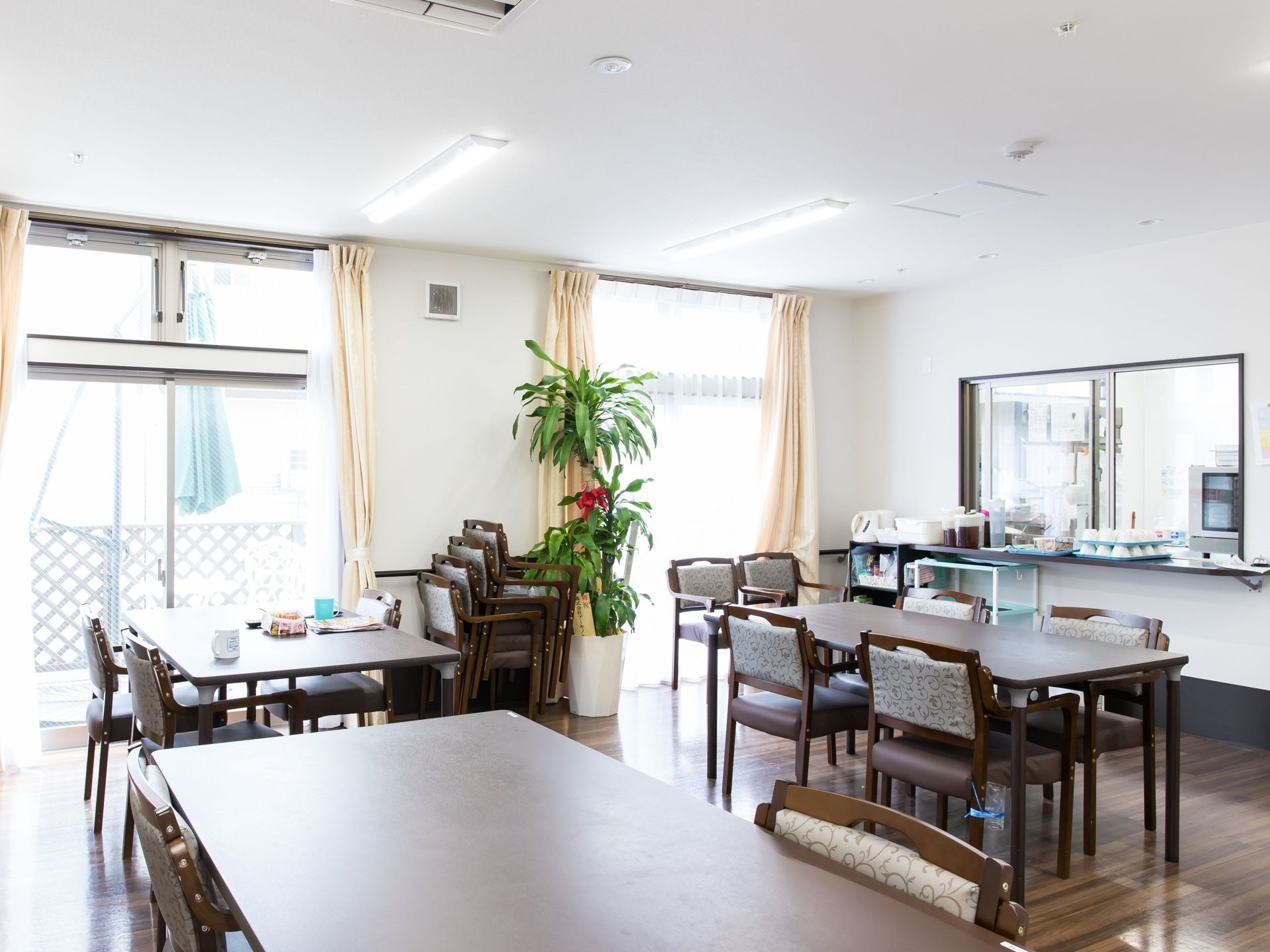 ダイニングテーブルが並べられた食堂がある。調理室とはカウンター越しにつながっており、お茶や湯呑みが置かれている。