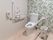 フローリングの床に白と葉っぱ模様のツートンの壁になっている。トイレの両側には手すりが設けられている。杖を掛ける金具が壁面に付いている。