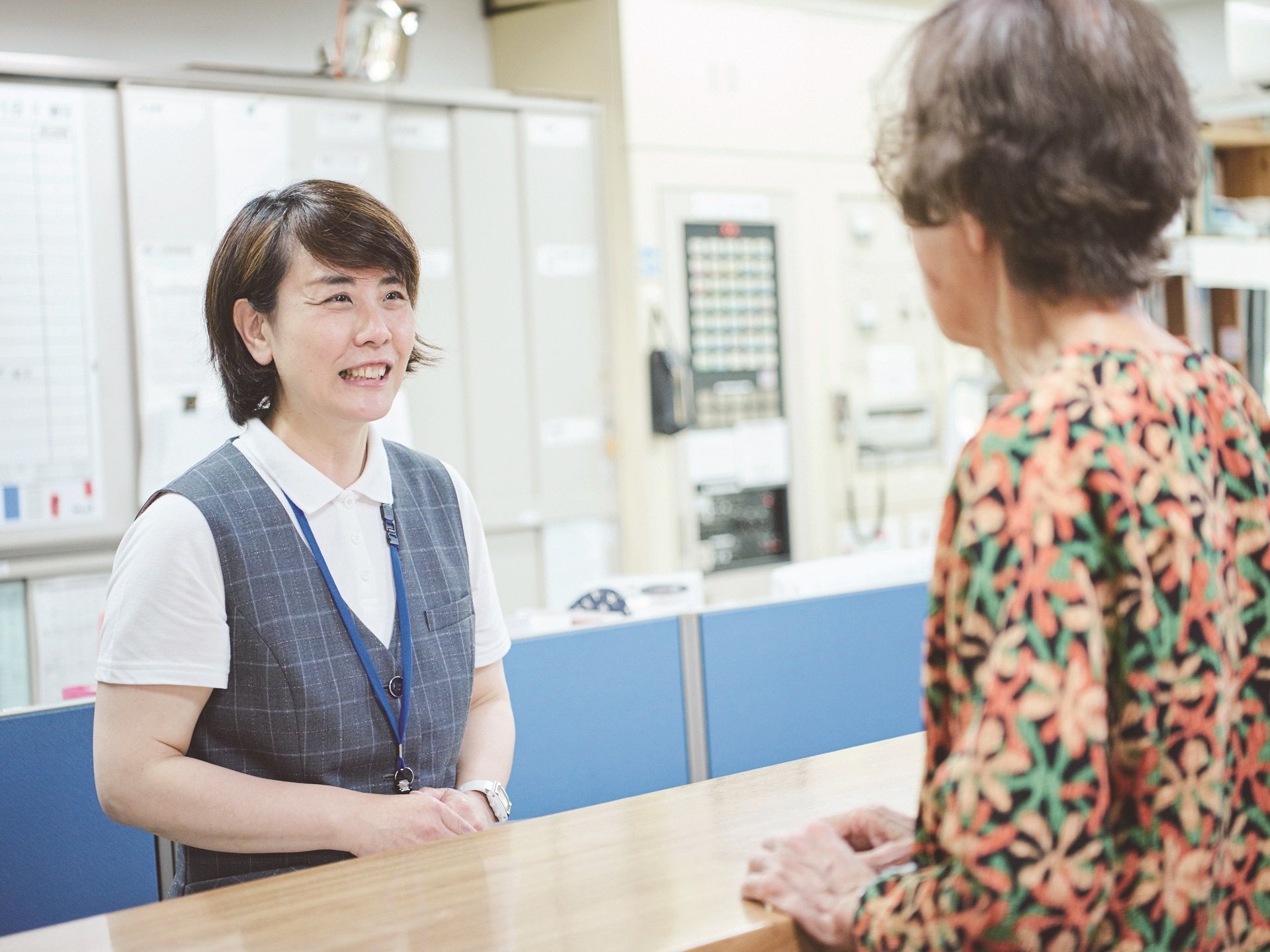 車いすから立ち上がろうとしている男性とそれを補助しようとしている女性スタッフの様子
