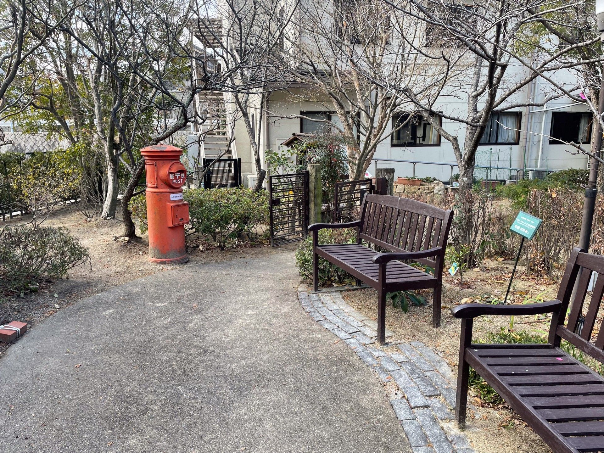 赤いポストとベンチの庭