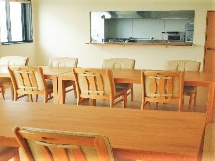 食堂には木製のダイニングテーブルが並び、厨房から見渡すことができる。