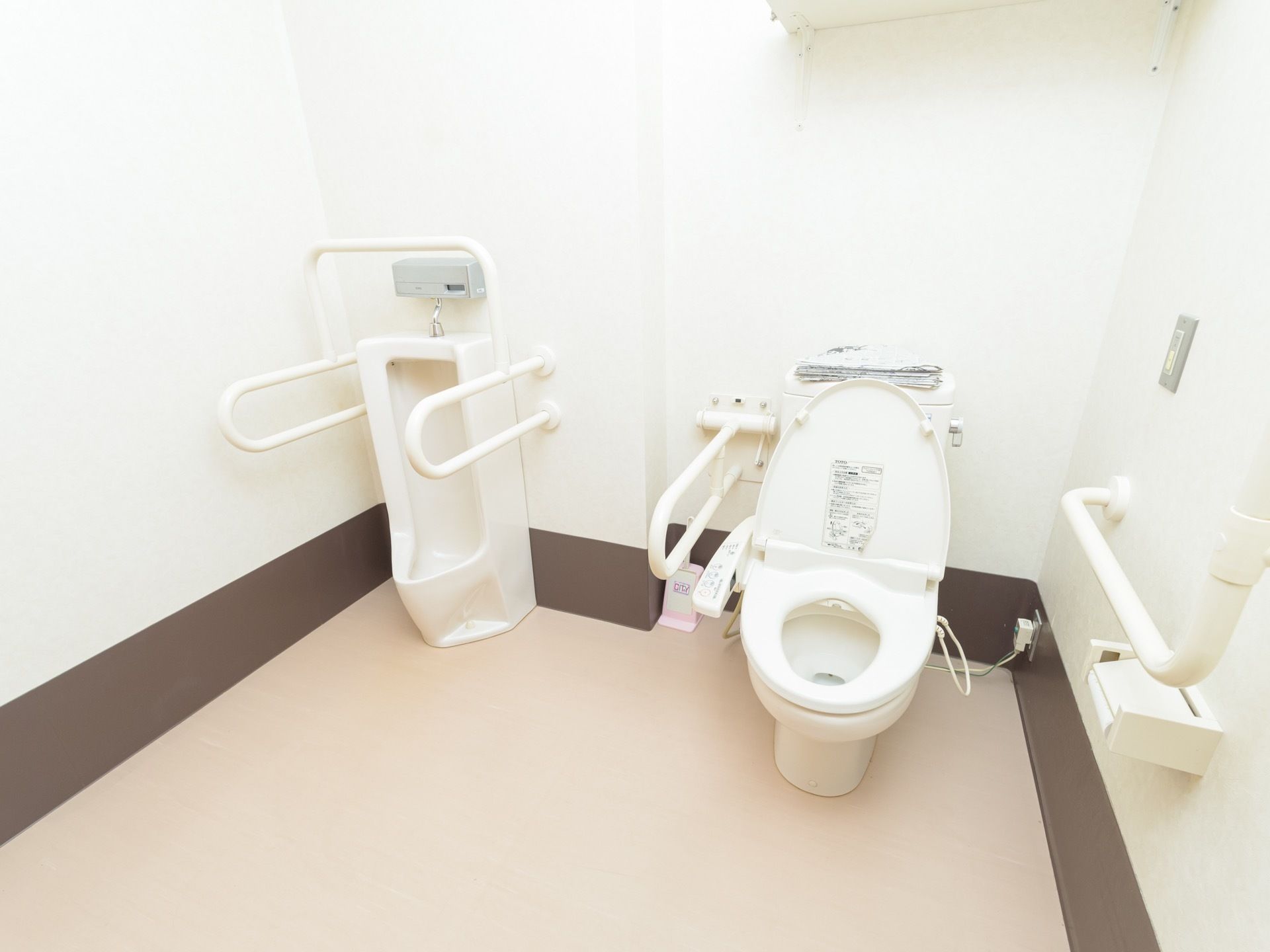 広々としたトイレに男性用トイレと洋式トイレが設置されている。洋式トイレの横に緊急呼び出しボタンがある。