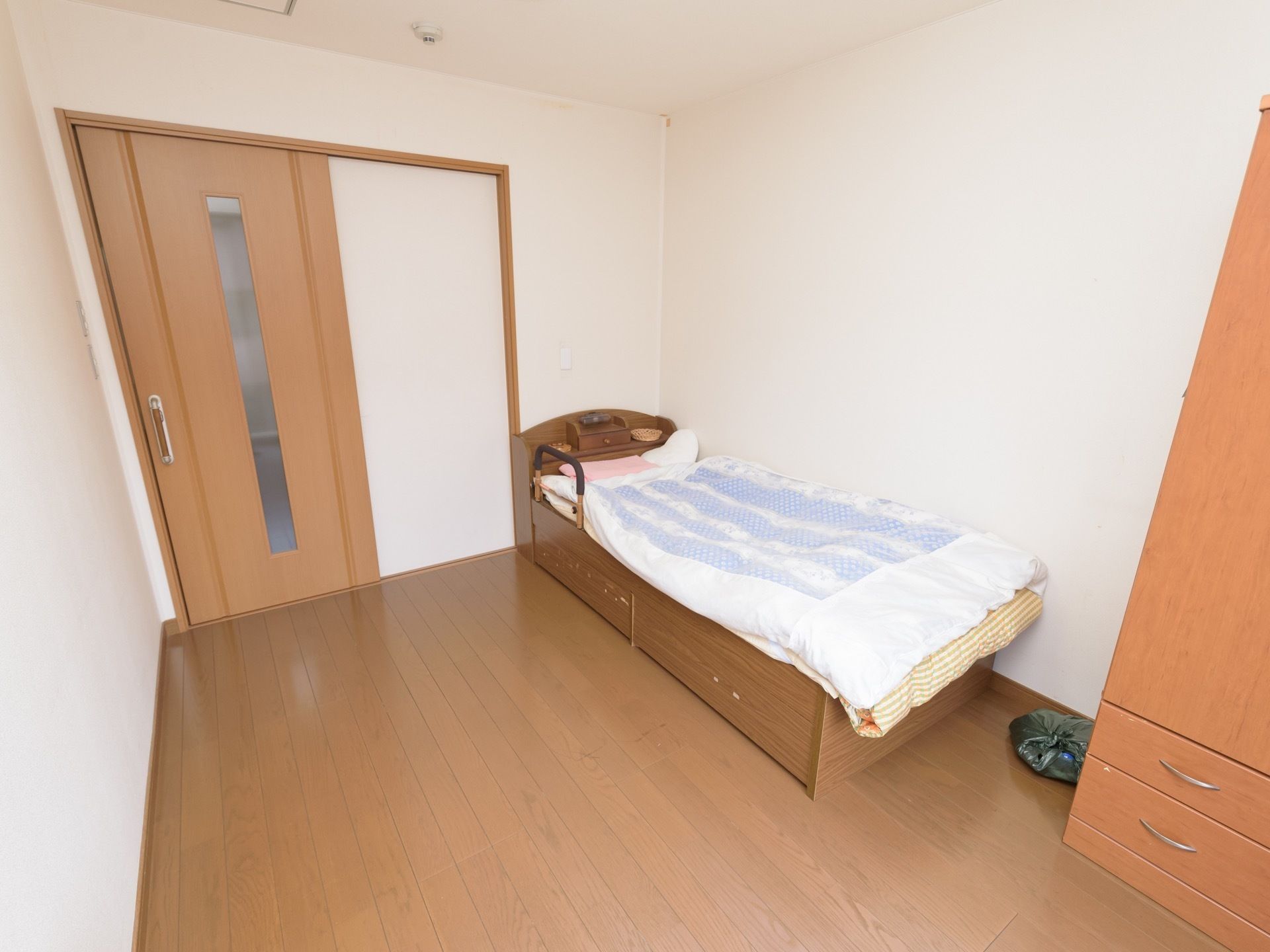 居室の床はフローリングで、手すりがついたベッドが設置されている。ドアはスライド式で、開けやすい構造になっている。