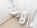 右手に温水洗浄便座を取りつけたトイレがある。壁には手すりがついており、折り畳み式、固定式の２種類ある。