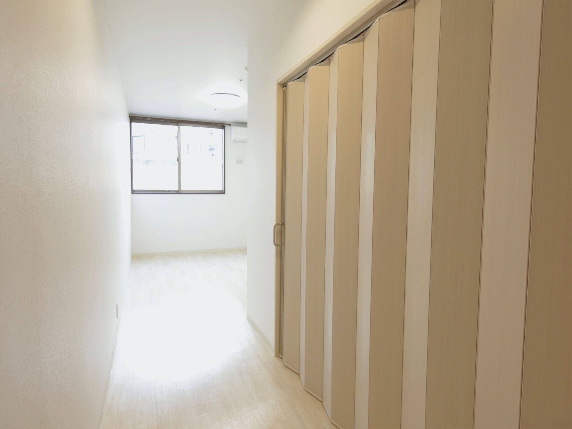 居室にあるパネルドアは、トイレスペースを区切る役割を果たしている。奥には窓があり、ベッドなどを配置できる空間が広がっている。